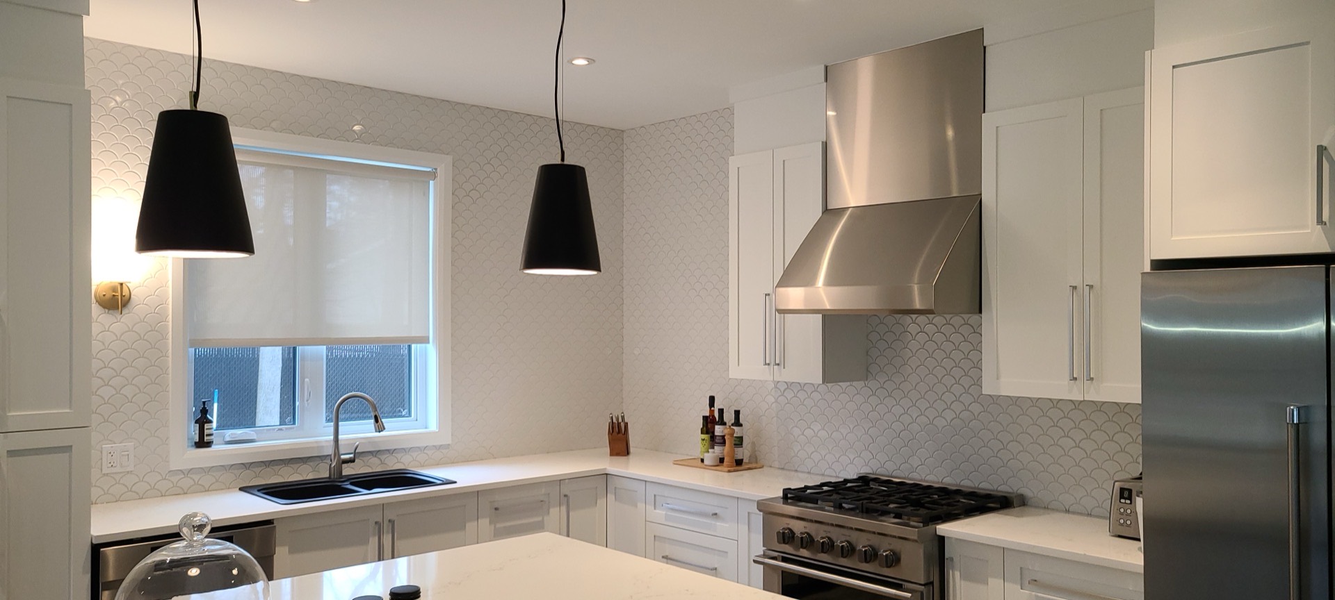 Cuisine rénovée par Les Installations DB, armoires blanches et hotte en inox