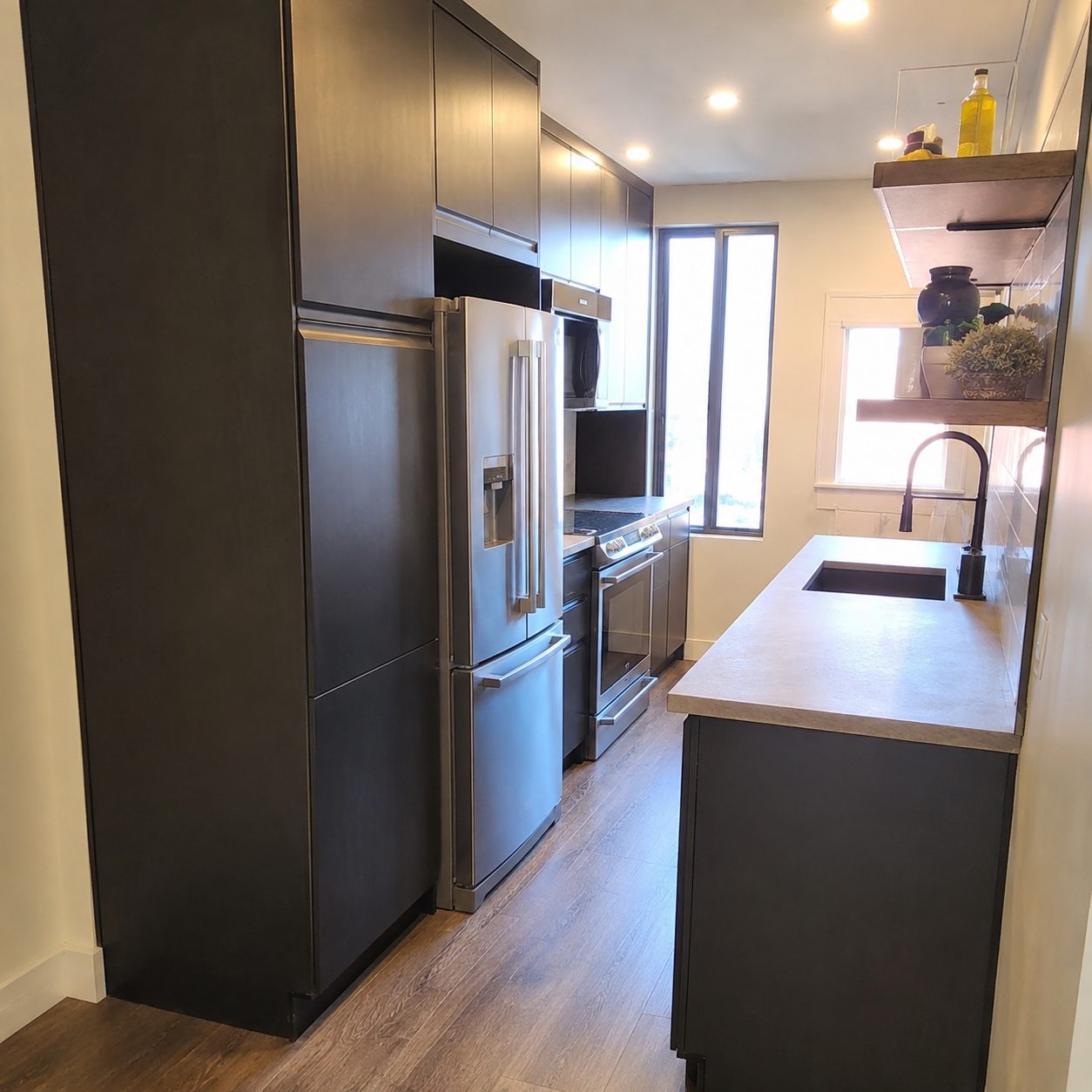 Cuisine rénovée par Les Installations DB, armoires foncées et électroménagers en inox