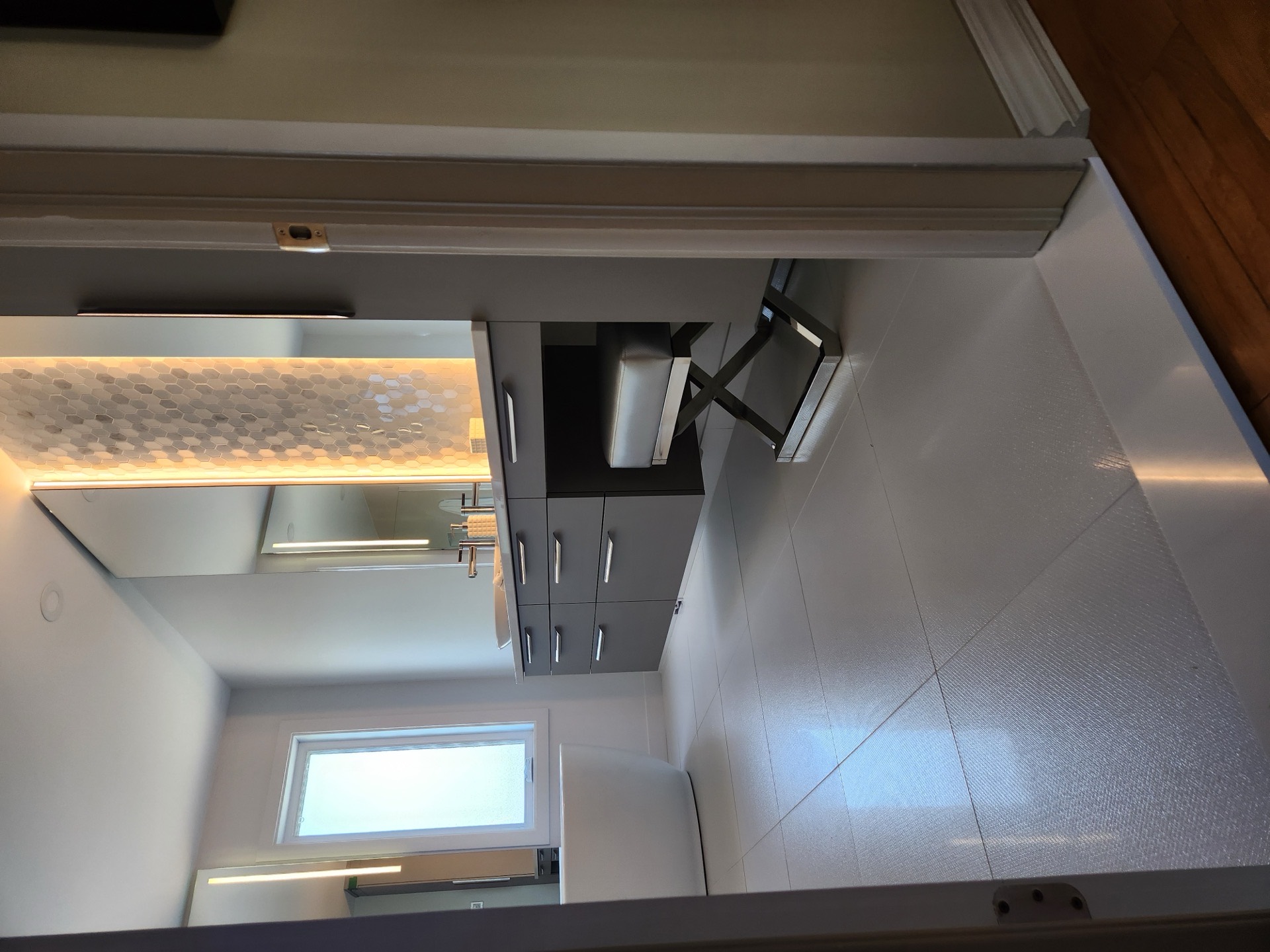 Salle de bain rénovée par Les Installations DB, vanité flottante et mur en mosaïque rétroéclairé